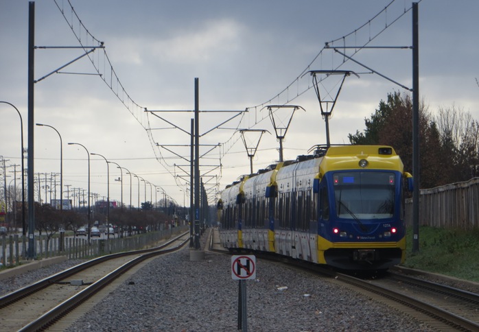 Outside the city's core area, much of the Blue Line alignment, running on former freight railroad right-of-way, parallels Hiawatha Avenue, seen on the far left in this view. Photo: L. Henry.